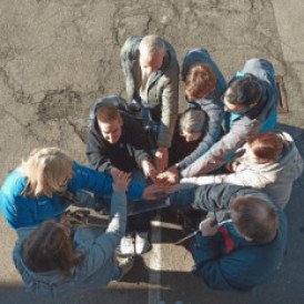 Menschen stehen im Kreis und halten ihre Hände übereinander